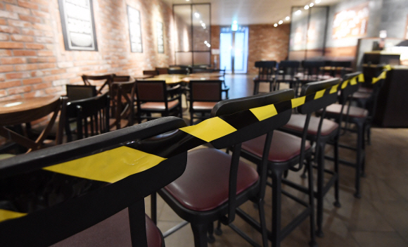 수도권 지역 사회적 거리 두기 2단계로 격상된 24일 서울의 한 커피 전문점에서 사용이 금지된 테이블과 의자가 쌓여 있다. 이날부터 사회적 거리 두기 2단계로 격상됨에 따라 유흥시설은 운영할 수 없고 카페는 하루종일, 식당은 저녁 9시부터 포장과 배달 판매만 할 수 있다. 2020.11.24 오장환 기자 5zzang@seoul.co.kr