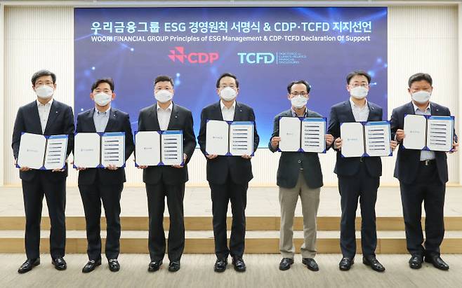 손태승 우리금융그룹 회장(왼쪽 네번째)이 15일 서울시 중구 소재 우리은행 본점 시너지홀에서 열린 2021년 경영전략회의에서 그룹사 CEO들과 함께 ESG경영원칙 서명식 및CDP(탄소정보공개프로젝트)·TCFD(기후관련재무정보공개 권고안) 지지선언 기념촬영을 하고 있다. 우리금융그룹 제공