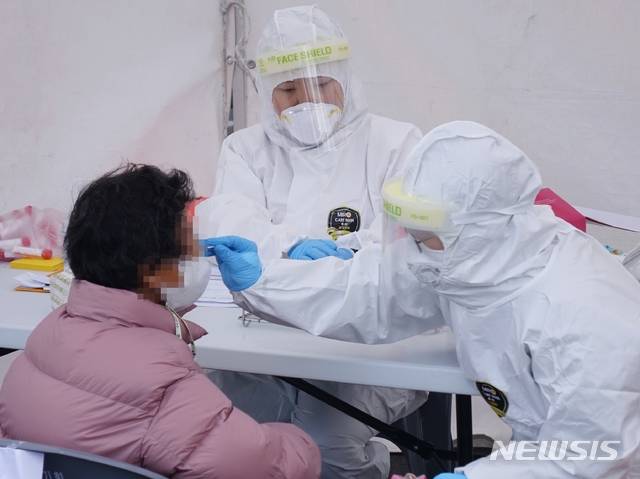 [제주=뉴시스]강경태 기자 = 제주지내 사우나발 신종 코로나바이러스 감염증(코로나19) 확진자가 급증하면서 20일 오후 제주시 동문시장 인근에 마련된 선별진료소에서 65세 이상 상인 등을 대상으로 검체 채취가 진행되고 있다. 2020.12.20. ktk2807@newsis.com
