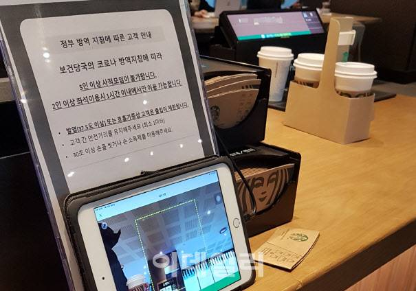 카페 매장 내 취식이 제한적으로 다시 재개한 첫날 18일 서울 용산구 한 스타벅스커피에서 매장 안팎으로 ‘5인 이상 사적모임 불가’, ‘2인 이상 좌석 이용 시 1시간 이내 가능’ 등 정부 방역 지침 안내문을 내걸고 있다.(사진=김범준 기자)
