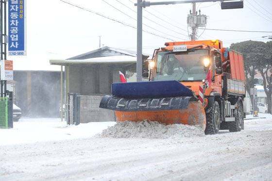 이틀째 폭설이 내린 지난 8일 오전 제주시 용담동 도로에서 제설차가 눈을 치우고 있다. 연합뉴스