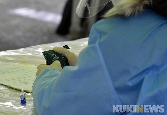 강추위가 이어지고 있는 11일 서울 한강대로 서울역 광장에 마련된 코로나19 임시 선별검사소에 의료진이 핫팩으로 손을 녹이고 있다. 박태현 기자