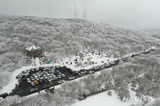 [서귀포=뉴시스]우장호 기자 = 제주 한라산에 1m가 넘는 폭설이 내린 가운데 17일 오후 제주 한라산 1100고지 휴게소 인근 도로에 관광객들이 찾아와 설경을 감상하며 즐거운 시간을 보내고 있다. 2020.12.17. woo1223@newsis.com