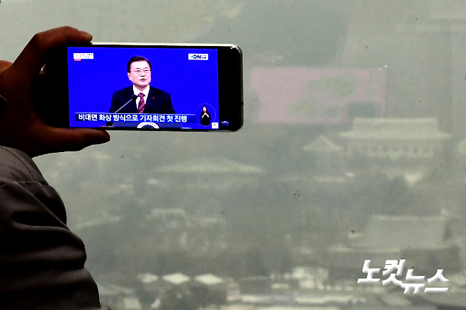 18일 오전 서울 광화문역 인근 한 사무실에서 직장인들이 유튜브를 통해 문재인 대통령 신년 기자회견을 시청하고 있다. 황진환 기자