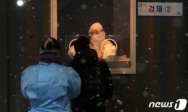 18일 오후 서울역 앞 광장에 마련된 코로나19 임시선별진료소에서 의료진이 검체를 채취하고 있다. /뉴스1 © News1 김진환 기자