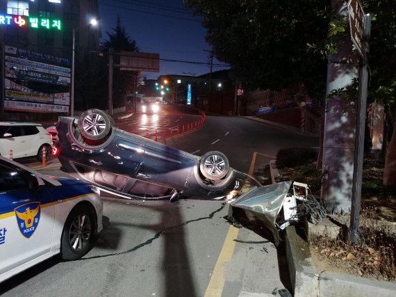 ▲19일 부산 남구 동명대학교 앞 사거리에서 발생한 차량 전복사고 모습.