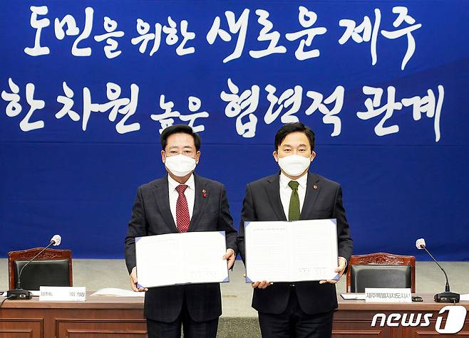 19일 오후 제주도청 탐라홀에서 열린 제주도·제주도의회 상설정책협의회에서 원희룡 제주도지사와 좌남수 제주도의회 의장이 4차 재난지원금 선별 지원 등의 내용을 담은 합의문을 들고 기념촬영을 하고 있다.(제주도 제공)2021.1.19 /뉴스1 © News1