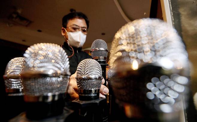 헬스장과 당구장, 노래방 등 다중이용시설 이용이 재개된 18일 오후 서울 종로구 한 노래방에서 점주가 마이크를 소독하고 있다. /뉴시스