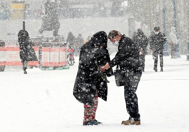 A Seoulite offers his jacket and gloves to a homeless man in front of Seoul Station on Jan. 18. (photos by Baek So-ah, staff photographer)
