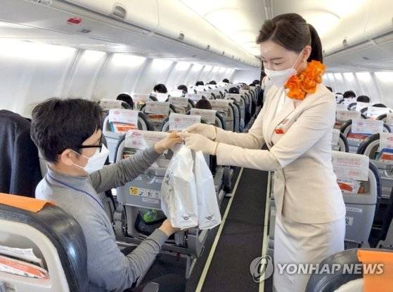 제주항공이 지난해 12월 일본 상공을 비행하고 돌아오는 무착륙 국제 관광비행을 실시했다. 한 탑승객이 기내에서 면세품을 사고 있는 모습.
