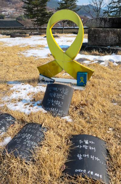 세월호 참사 희생자를 기리는 천일기도가 진행된 목탑지 가운데 노란 리본 조형물 아래엔 “유민아 사랑해”라고 적은 기와 불사가 놓였다.