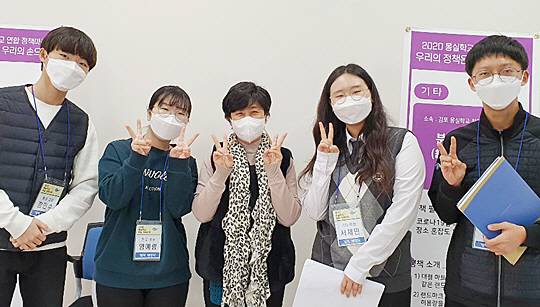 지난해 11월 경기 성남시 성남몽실학교 개관식에서 김현주(가운데) 교사와 학생들이 ‘정책마켓활동’을 홍보하며 기념촬영을 하는 모습. 몽실학교는 경기 의정부시를 시작으로 성남·고양·안성 등 6곳으로 확대됐다.  초록우산어린이재단 제공