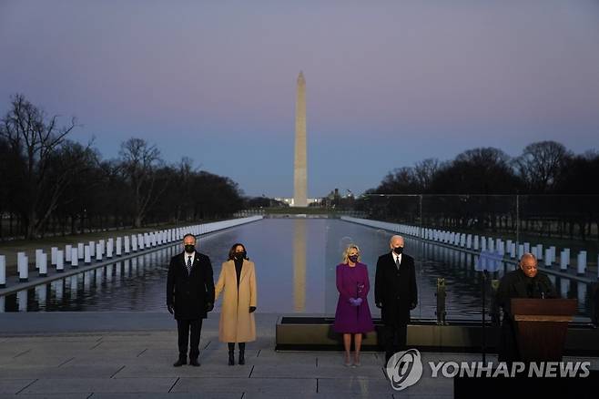 코로나19 희생자 추모식 참석한 바이든·해리스 부부 (워싱턴 AP=연합뉴스) 조 바이든 미국 대통령·카멀라 해리스 부통령 당선인 부부가 19일(현지시간) 저녁 워싱턴DC 링컨기념비에서 열린 신종 코로나바이러스 감염증(코로나19) 희생자 추모식에 참석, 워싱턴기념탑을 배경으로 나란히 서서 윌턴 그레고리 추기경의 연설을 듣고 있다. leekm@yna.co.kr