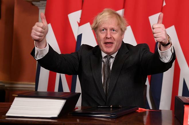 보리스 존슨 영국 총리가 지난해 12월 30일(현지 시각) 브렉시트 협정문에 서명한 뒤 양손 엄지를 치켜들며 기뻐하고 있다. /로이터 연합뉴스
