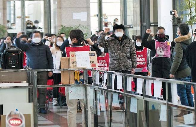 20일 오후 서울 여의도 LG트윈타워 중앙 로비에서 민주노총 조합원들이 정년 연장 등을 요구하며 농성하는 30여명 청소 근로자들과 함께 집회를 가졌다. /이태경 기자