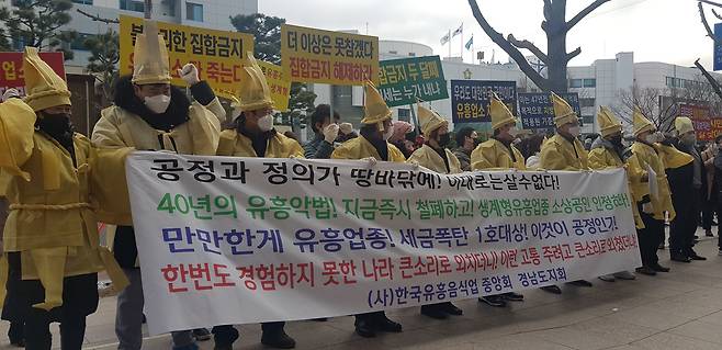 한국유흥음식업중앙회 경남도지회원이 21일 오후 경남 창원시 의창구 경남도청 입구에서 영업 허가증을 불에 태우고 있다.  이 단체는 코로나19 관련 사회적 거리두기 방역 완화 대상에서 제외된 것에 반발해 이날 기자회견을 열고 허가증을 불에 태웠다. /창원=김준호