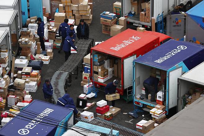 21일 서울시내 한 택배 물류센터에서 배송기사들이 택배차에 물건을 옮겨 싣고 있다.