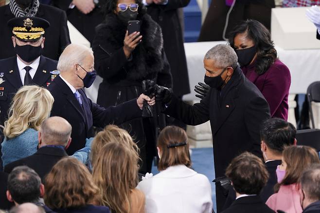 바이든·오바마 ‘주먹 인사’ 조 바이든 미국 대통령(왼쪽)과 버락 오바마 전 대통령이 20일(현지시간) 열린 제46대 대통령 취임식에서 주먹 인사를 하고 있다. 워싱턴 | 로이터연합뉴스