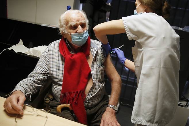 18일(현지시간) 프랑스 파리 제7구의 한 백신 접종센터에서 94세 노인이 화이자·바이오엔테크의 코로나19 백신을 접종받고 있다. [연합]