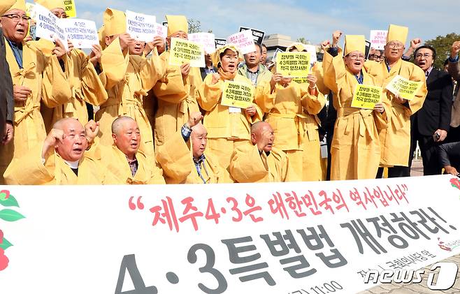 제주4·3 희생자 유족들이 서울 여의도 국회 정문 앞에서 제주4·3특별법 개정안의 국회 통과를 촉구하는 기자회견을 열고 구호를 외치고 있다. 2019.10.18/뉴스1 © News1 김명섭 기자