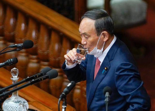 스가 요시히데 일본 총리가 20일 국회에서 코로나19 대응과 도쿄 올림픽 개최에 대한 야당 대표 질의에 답변하기에 앞서 물을 마시고 있다. 도쿄=EPA연합뉴스
