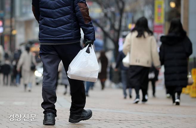 한 노숙인이 ‘명동밥집‘에서 나눠준 도시락을 들고 인근 명동 거리를 걸어가고 있다.  권도현 기자