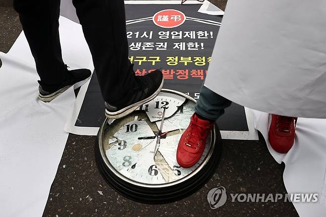 21시 영업제한 해제 촉구하는 참석자들 (서울=연합뉴스) 윤동진 기자 = 15일 오후 서울 여의도 더불어민주당 당사 앞에서 열린 음식점·호프 비상대책위원회, 생존권보장 요구 기자회견'에서 참석자들이 관련 퍼포먼스를 하고 있다. 2021.1.15 mon@yna.co.kr