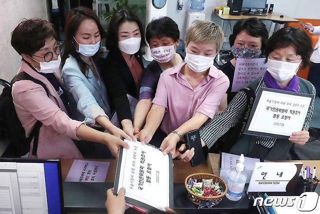 고 박원순 전 서울시장을 성추행으로 고소한 피해자의 법률 대리인 김재련 변호사 및 관계자들이 2020년 7월28일 오전 서울 중구 국가인권위원회 앞에서 기자회견을 마치고 박원순 전 서울시장 위력에 의한 성폭력 사건의 국가인권위원회 직권조사를 촉구하는 요청서를 제출하고 있다. 2020.7.28/뉴스1 © News1 임세영 기자