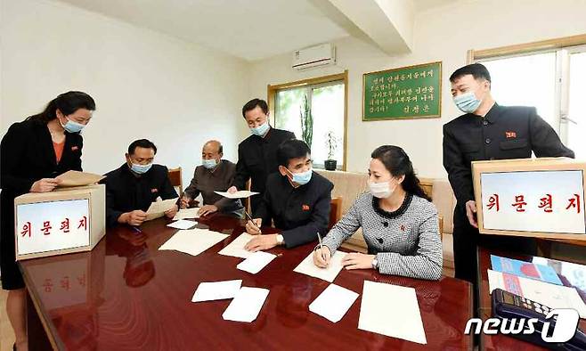 (평양 노동신문=뉴스1) = 수해 복구 현장에 나선 군인 장병에게 위문편지를 쓰는 북한 주민. 이들은 모두 오른손으로 편지를 쓰고 있다. [국내에서만 사용가능. 재배포 금지. DB 금지. For Use Only in the Republic of Korea. Redistribution Prohibited] rodongphoto@news1.kr