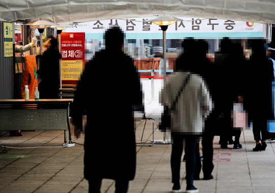 21일 오전 서울 중구 서울시청 앞 임시선별검사소에서 시민들이 신종 코로나바이러스 감염증(코로나19) 검사를 받기 위해 줄지어 서 있다. 이날 코로나19 확진자는 401명이 신규 확진돼 이틀째 400명대 초반을 기록했다.  연합뉴스