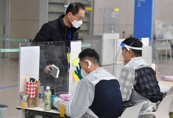 인천국제공항 제2여객터미널에서 방역 관계자들이 해외 입국자들에게 동선을 안내하고 있다. 박태현 기자