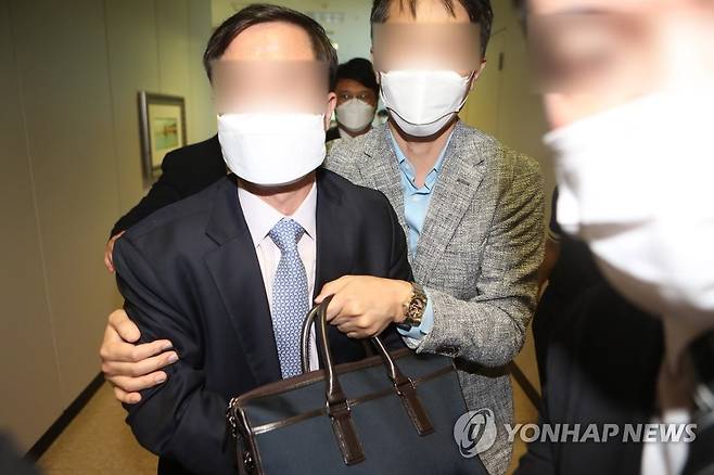 구속영장 심사받고 나오는 대구경찰청 경무관 (대구=연합뉴스) 김현태 기자 = 식품업체 수사를 무마한 혐의를 받는 대구경찰청 소속 경무관(짙은 색 양복)이 지난해 9월 25일 오후 대구지방법원 서부지원에서 구속영장실질심사를 받고 나오고 있다. [연합뉴스 자료사진]