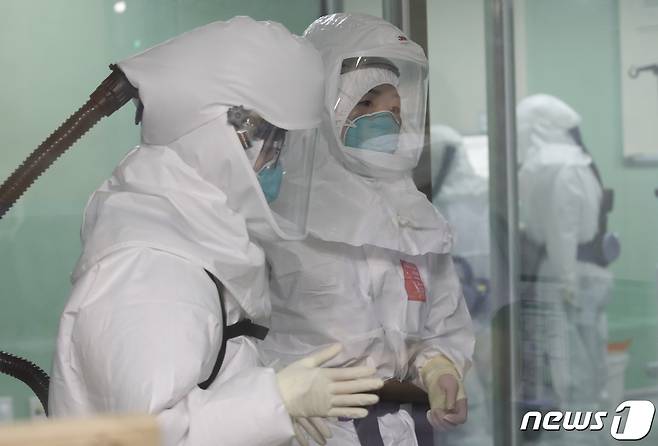 국내에서 신종 코로나바이러스 감염증(코로나19) 확진자가 처음 발생한지 1년째 되는 날인 지난 20일 방호복을 착용한 울산대병원 의료진들이 환자를 돌보기 위해 특수(음압)중환자실로 들어서고 있다. 2021.1.20/뉴스1 © News1 윤일지 기자