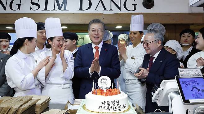 문재인 대통령이 2019년 1월 24일 전국경제투어로 대전을 방문해 성심당 빵집에서 튀김 소보로를 구매한 뒤 직원들로부터 깜짝 생일 축하 케이크를 받고 있다. /뉴시스