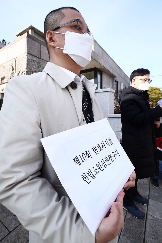 이경수 법조문턱낮추기실천연대 대표가 25일 오후 서울 종로구 헌법재판소 앞에서 제10회 변호사시험 공법 제2문 전원 만점처리 등의 의결에 대한 헌법소원 청구서를 들어보이고 있다.(사진=연합뉴스)