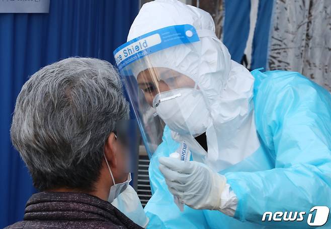 대전 중구 대흥동에 위치한 비인가 IEM국제학교에서 학생과 교직원 등 127명이 신종 코로나바이러스 감염증(코로나19) 확진 판정을 받은 가운데 25일 오후 대전 중구 한밭체육관에 마련된 임시선별진료소에서 시민들이 검사를 받고 있다. 2021.1.25/뉴스1 © News1 김기태 기자