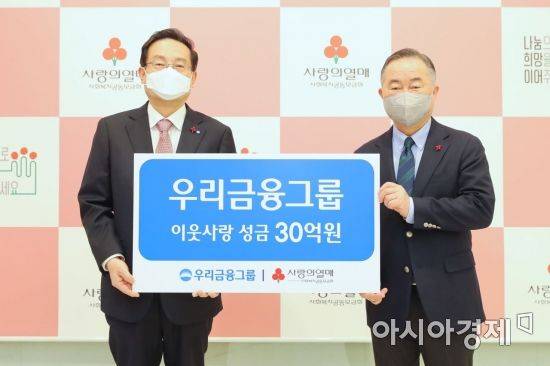 우리금융그룹은 25일 사회복지공동모금회에 성금 30억을 기탁했다. 손태승 우리금융그룹 회장(왼쪽)이 예종석 사회복지공동모금회 회장(오른쪽)과 기념촬영을 하고 있다.