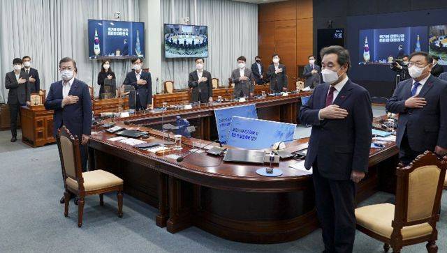 문재인 대통령이 25일 오후 청와대에서 열린 복지부·식약처·질병청 2021년 업무보고에 참석, 국기에 경례하고 있다. 오른쪽은 더불어민주당 이낙연 대표. 연합뉴스