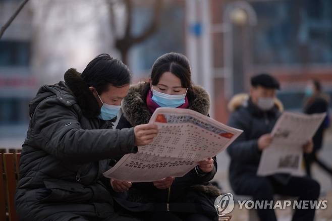 노동신문 읽고 있는 평양 주민들 (평양 AFP=연합뉴스) 북한 평양의 미래과학자거리에서 11일 주민들이 노동당 기관지인 노동신문을 읽고 있다. sungok@yna.co.kr