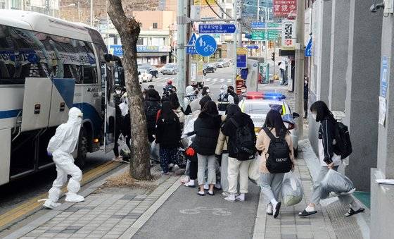 신종 코로나바이러스 감염증(코로나19) 확진자가 127명 무더기로 발생해 초비상이 걸린 25일 오후 대전 중구 종교단체 소속 비인가 시설(IEM국제학교)에서 학생들이 충남 아산 생활치료센터로 입소하기 위해 버스에 탑승하고 있다. 김성태 기자