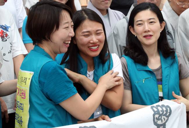 철도노사가 KTX 해고 승무원 복직을 합의한 2018년 7월21일 12년째 투쟁을 이어온 KTX 해고 승무원들이 서울역 플랫폼 중앙계단에서 투쟁 해단식 기자회견을 하며 웃고 있다.연합뉴스