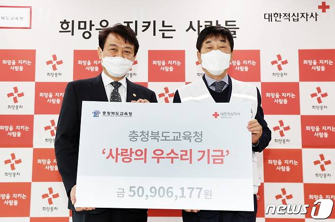 27일 오후 김병우 충북교육감(왼쪽)이 김경배 적십자사 충북지사 회장에게 사랑의 우수리 성금 5000여만원을 전달하고 있다.(충북교육청 제공).2021.01.27.© 뉴스1
