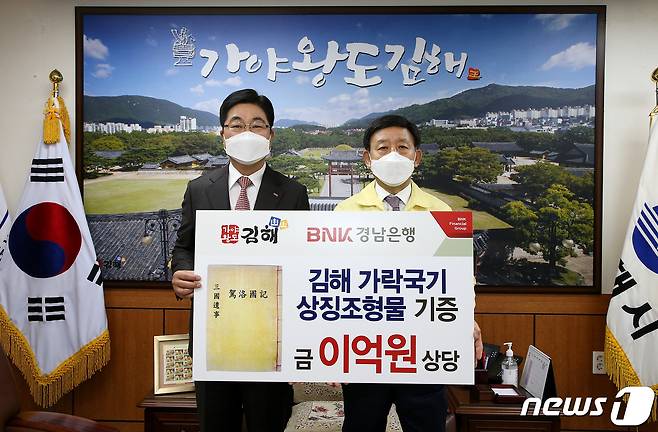 황윤철 BNK경남은행(왼쪽)이 허성곤 김해시장을 만나 가락국기 상징조형물 기증서를 전달하고 있다. © 뉴스1