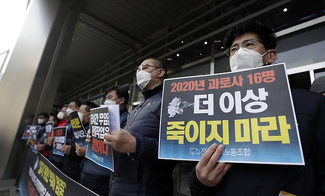 27일 오후 서울 중구 한진택배 본사 앞에서 택배노동자 과로사 대책위원회 위원들이 총파업 돌입 선포 기자회견에서 손팻말을 들고 있다. 김혜윤 기자 unique@hani.co.kr