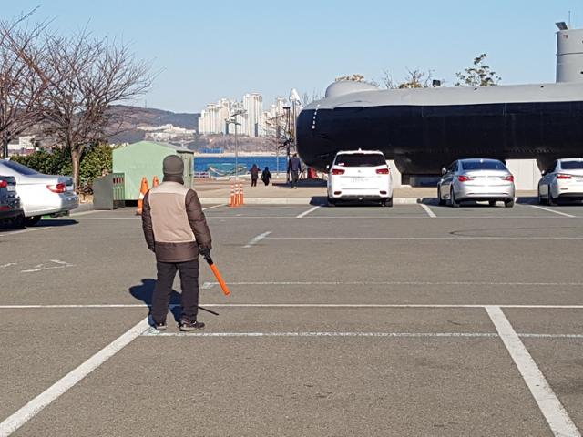국립해양박물관 주차관리원 이모씨가 온몸을 꽁꽁 감싼 채 주차장에 서서 일하고 있다. 주차장 30m 앞에 영도 바다라 바닷바람이 심하다. 이씨 제공