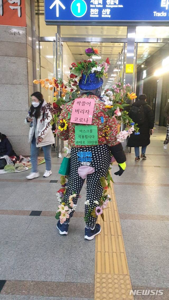 [수원=뉴시스] 수원역 일대에서 방역수칙 캠페인 벌이는 꽃아저씨. (사진=독자 제공)