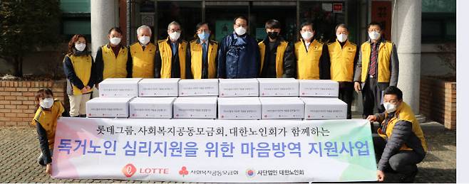 롯데 관계자들이 지난 27일 홀몸 어르신 심리 지원을 위한 마음 방역 꾸러미를 자원봉사센터에 전달한 후 기념촬영을 하고 있다. (사진=롯데)