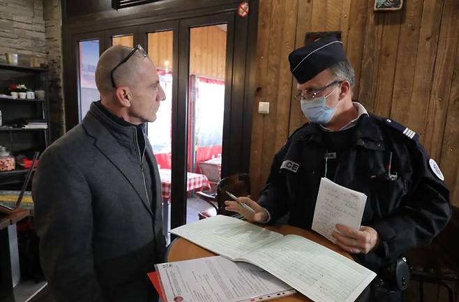 포피에서 손님들이 점심 식사를 마치고 돌아간 뒤 경찰이 찾아와 식당 장부를 들여다 보고 있다. 경찰은 식당 주인 크리스토프 윌슨이 고용한 외국인 한 명이 불법 체류자라는 것을 확인하고 크리스토프와 함께 연행해 조사하고 있다./니스 마탱