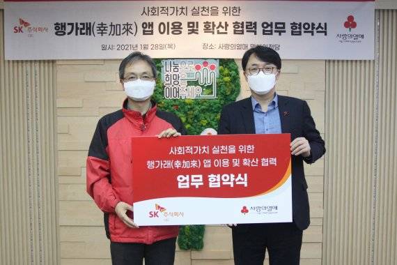SK㈜ C&C 김성한 SV담당(오른쪽)과 서울 사랑의열매 김용희 사무처장이 '사회적 가치 실천을 위한 행가래앱 이용 및 확산 협력' 협약 체결 후 기념 촬영을 하고 있다. SK㈜ C&C 제공