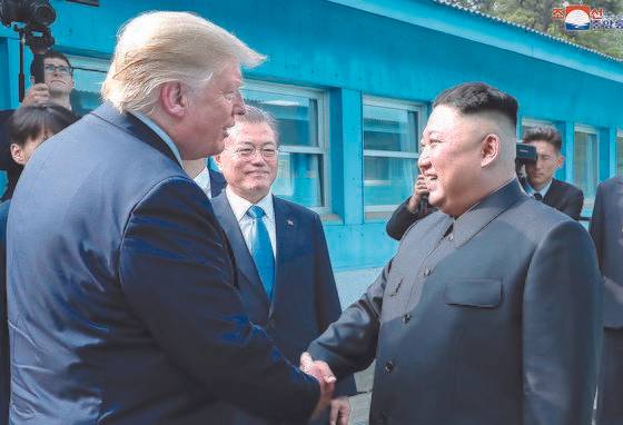 도널드 트럼프 미국 대통령과 김정은 북한 국무위원장이 2019년 6월 30일 오후 판문점에서 악수하고 있다. 문재인 대통령이 이를 바라보고 있다. [연합뉴스]